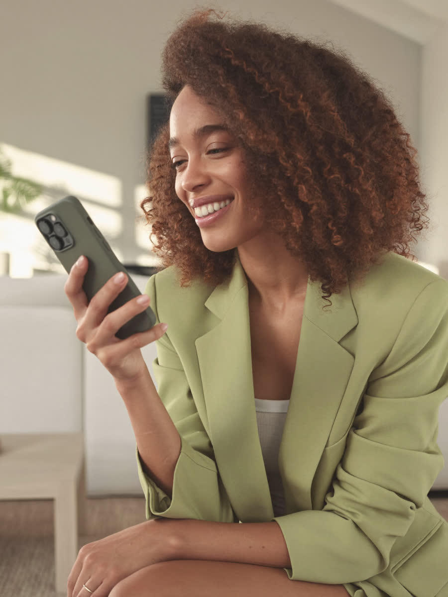 Mulher sorrindo ao ler o aviso no celular